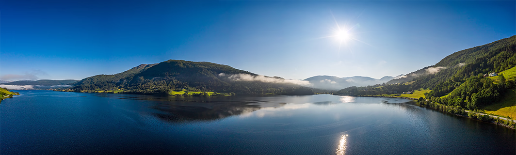 Ruhiger See inmitten von Bergen unter klarem Himmel, Sinnbild für innere Ruhe, Balance und Klarheit bei wichtigen Entscheidungen