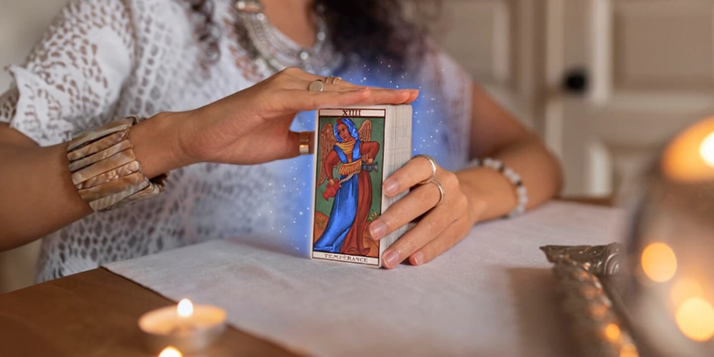 Frau mit einem Tarotkartenspiel und der Karte „Mässigkeit“, bereit für eine spirituelle Kartenlegung in einer entspannten Umgebung – Vorbereitung einer Kartenlegung bei Manticus