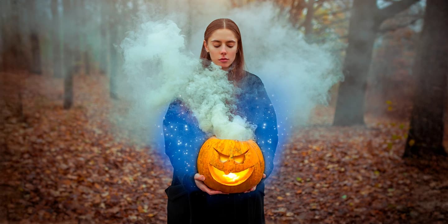 Junge Frau hält einen geschnitzten Kürbis mit magischem Rauch – Symbol für Halloween, Samhain und die spirituelle Bedeutung des 31. Oktober als Übergang zwischen den Welten.