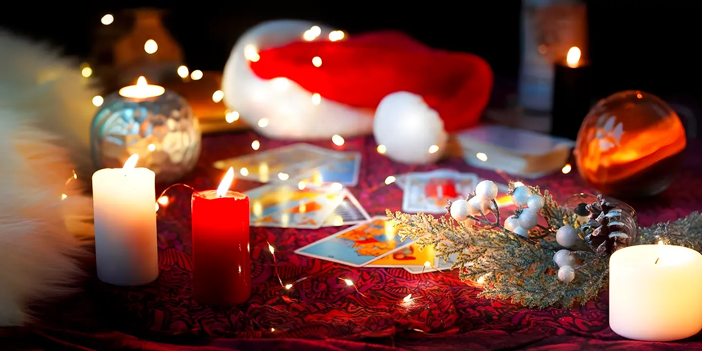 Weihnachtlicher Tisch mit Tarotkarten, Kerzen und winterlicher Dekoration, Symbol für spirituelle Führung und die Magie des Kartenlegens während der Feiertage.