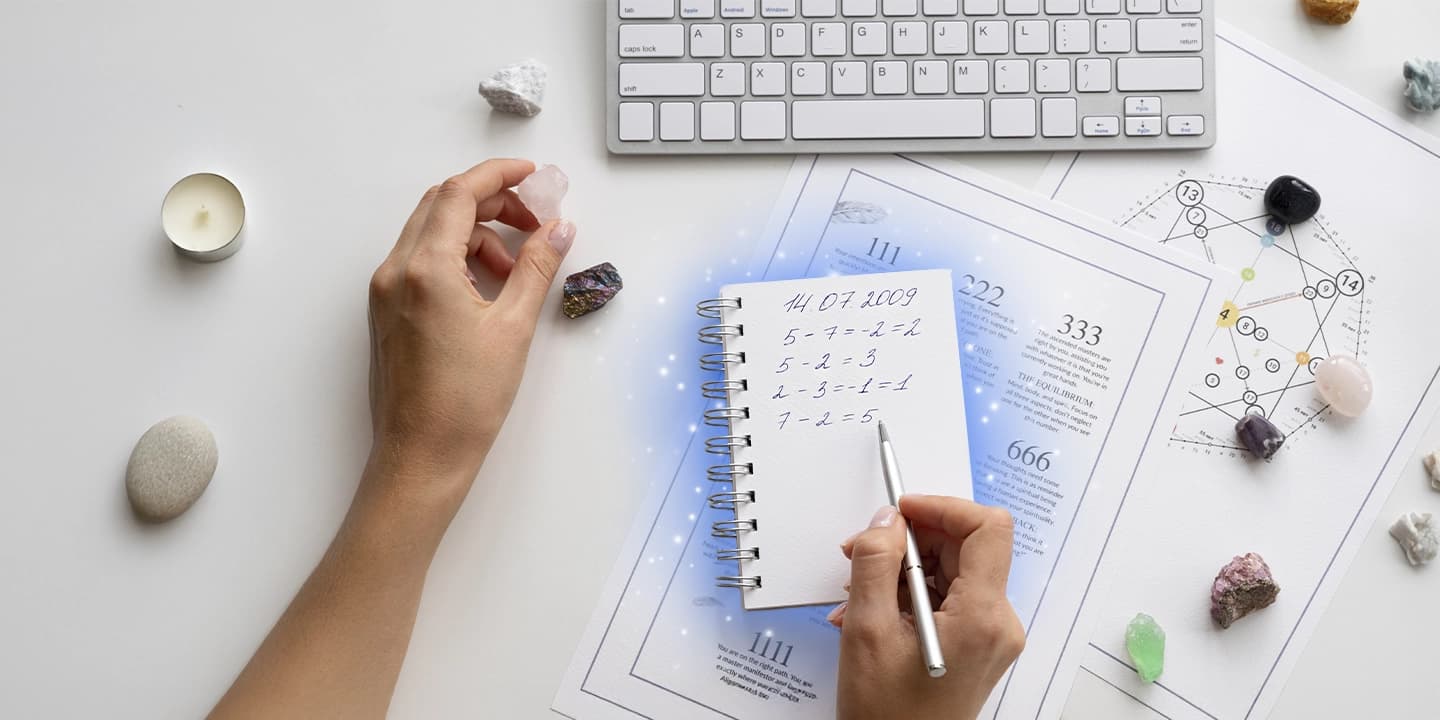 Notizblock mit numerologischen Berechnungen anhand eines Geburtsdatums, zusammen mit Kristallen und einer Tastatur, die die Berechnung des Lebensweges in der Numerologie veranschaulichen