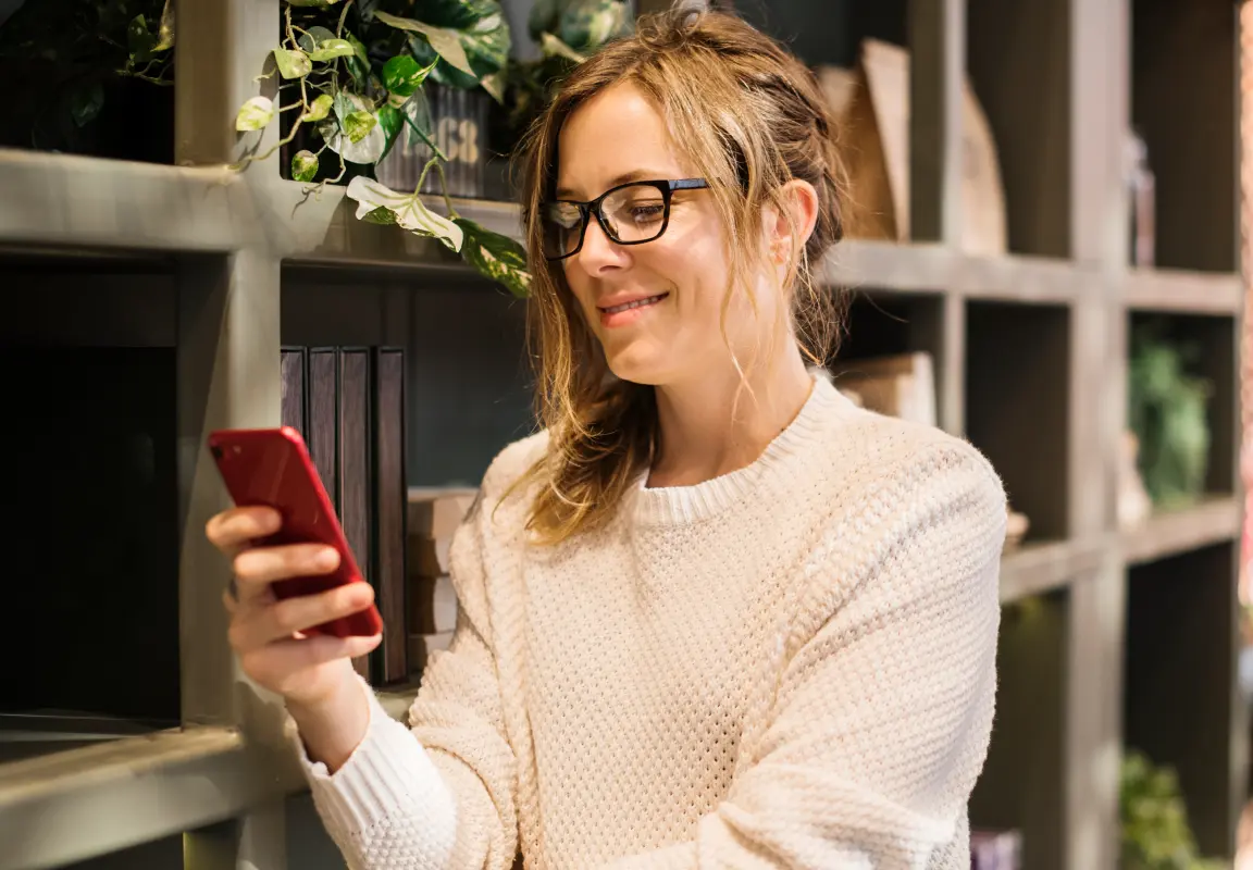 Frau liest ihr Horoskop auf dem Smartphone, Symbol für vertiefte astrologische Beratung und Analyse.
